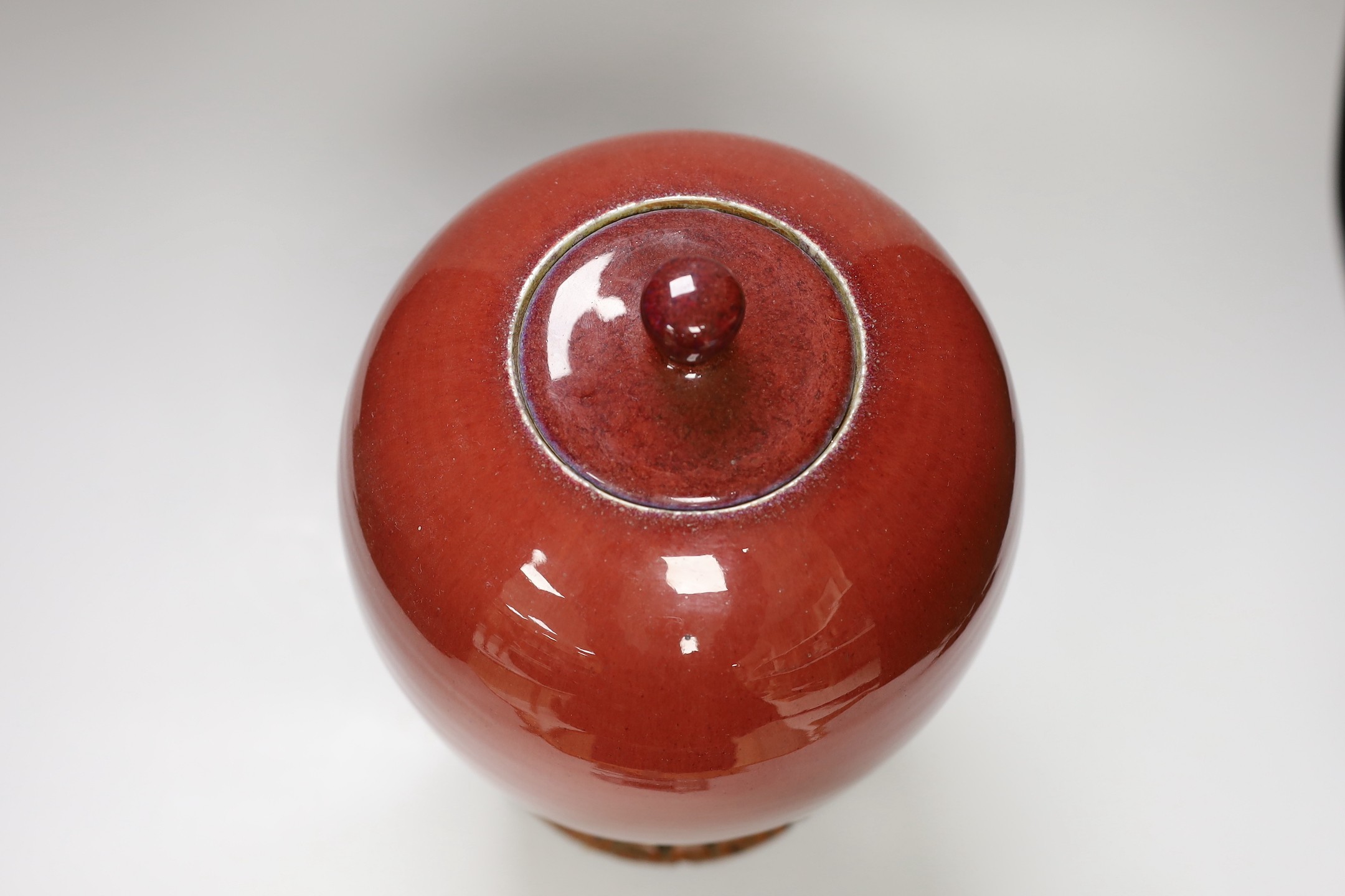 An early 20th century Chinese sang de boeuf jar and cover on hardwood stand, 36cm total